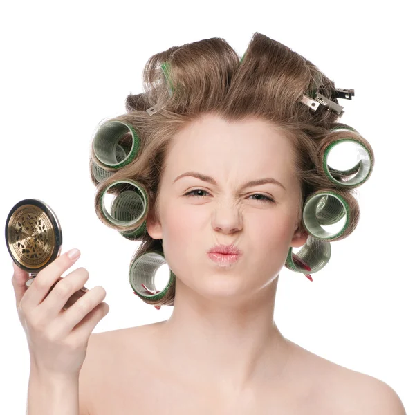 Žena v vlasy válec hledá v zrcadle — Stock fotografie