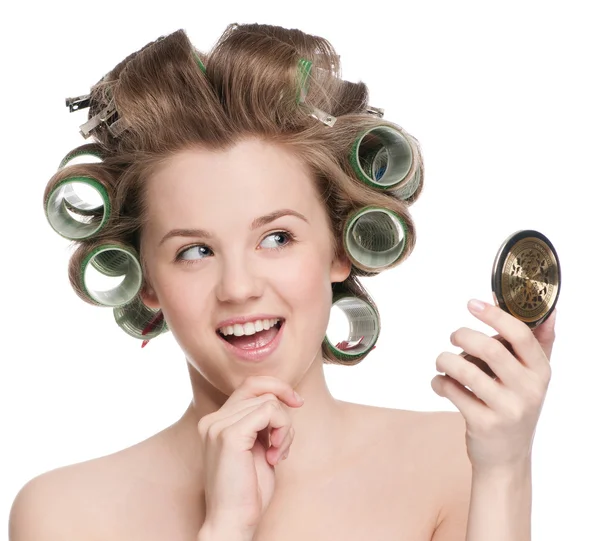 Woman in hair roller looking in mirror — Stock Photo, Image