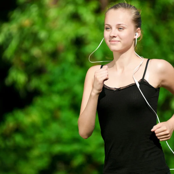 Jovem mulher correndo no parque verde — Fotografia de Stock
