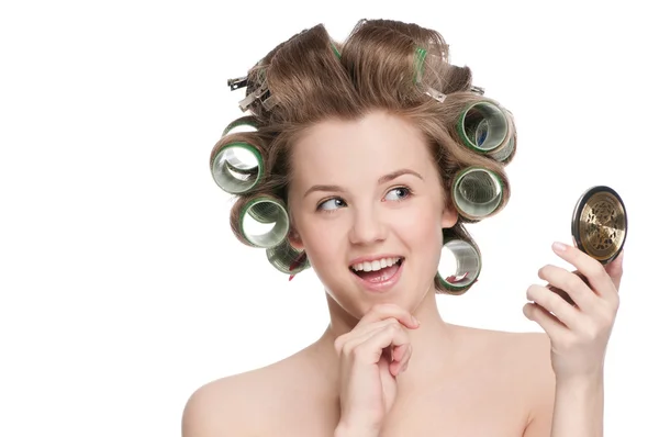 Frau in Haarrolle blickt in Spiegel — Stockfoto