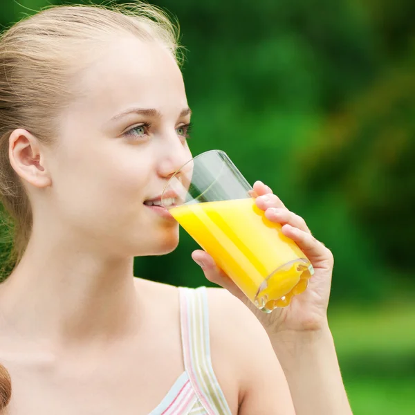Νεαρή γυναίκα πίνοντας χυμό πορτοκαλιού. εξωτερική — Φωτογραφία Αρχείου