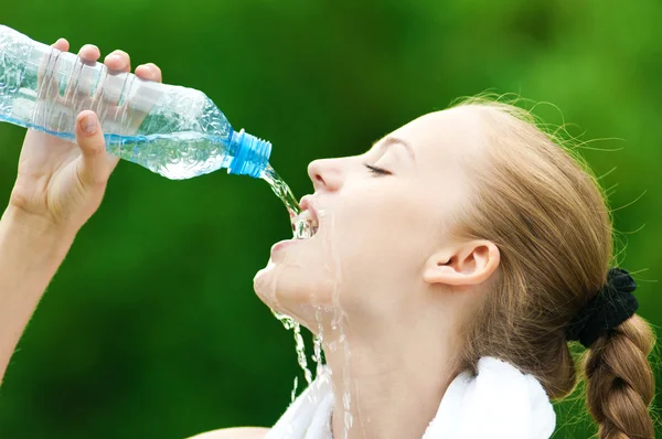 Женщина пьет воду после тренировки — стоковое фото
