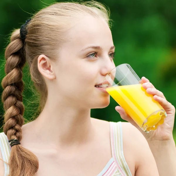 Jonge vrouw drinken sinaasappelsap. buiten — Stockfoto
