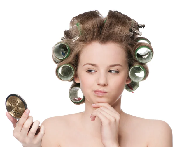 Mujer en rodillo de pelo mirando en el espejo —  Fotos de Stock
