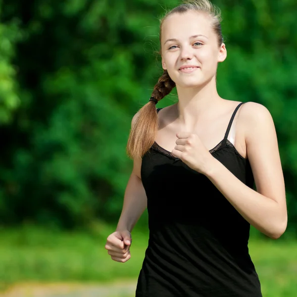 Mujer joven corriendo en el parque verde — Foto de Stock