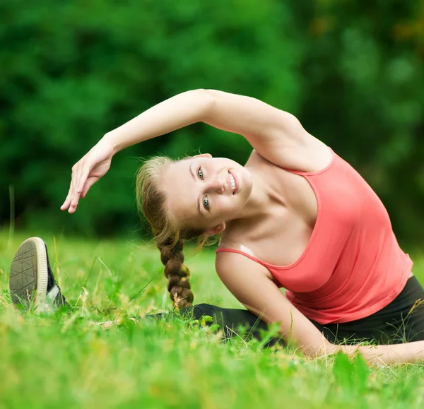 Νεαρή γυναίκα κάνει διατάσεις άσκηση — Φωτογραφία Αρχείου