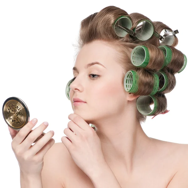 Kvinna i hår rulle ser i spegeln — Stockfoto