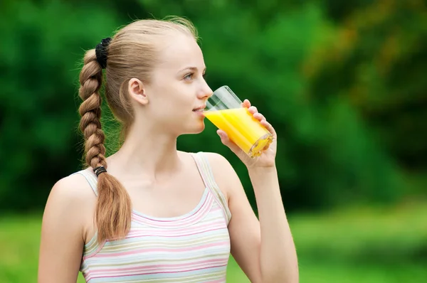Młoda kobieta pije sok pomarańczowy. odkryty — Zdjęcie stockowe