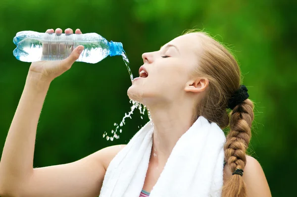 Женщина пьет воду после тренировки — стоковое фото