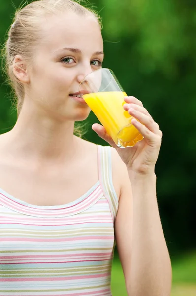 Mujer joven bebiendo jugo de naranja. Exterior — Foto de Stock