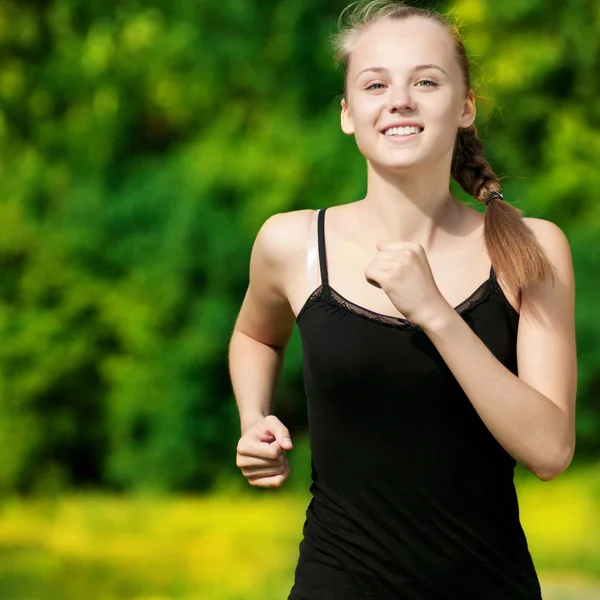 Young woman running in green park — Stock Photo, Image