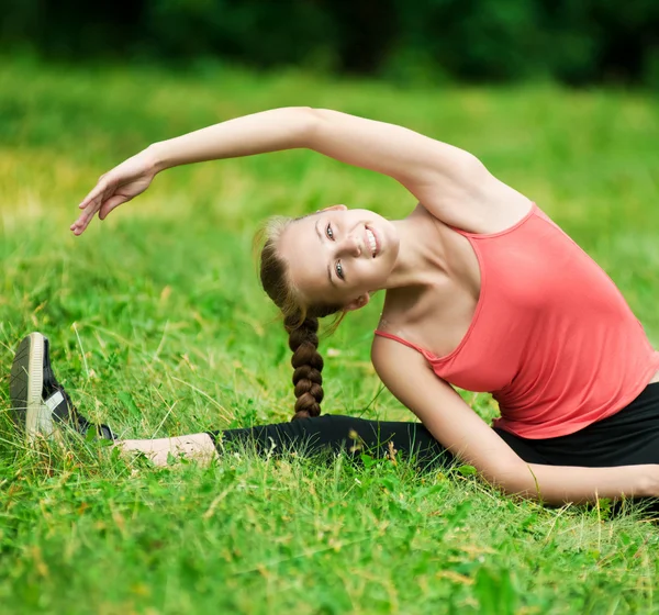 Mujer joven haciendo ejercicio de estiramiento — Foto de Stock