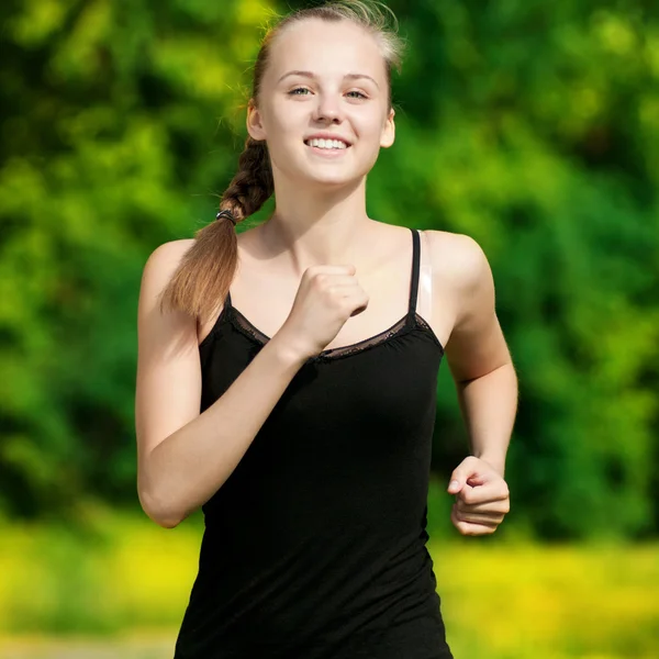 Yeşil park içinde çalışan genç bir kadın — Stok fotoğraf