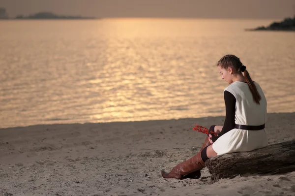 Donna sola seduta sulla costa del lago — Foto Stock