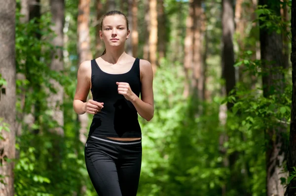 Schöne Frau läuft im grünen Park — Stockfoto