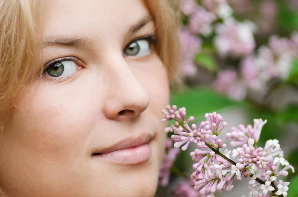 Mulher com flor lilás no rosto — Fotografia de Stock