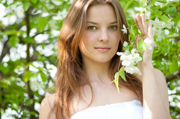 Vacker ung kvinna avkopplande i apple träd trädgård — Stockfoto
