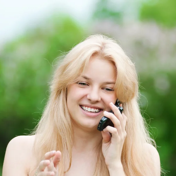 Młoda kobieta przy użyciu telefonu w parku — Zdjęcie stockowe