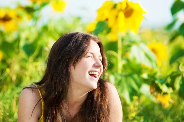 Schöne Frau in einem Sonnenblumenfeld — Stockfoto