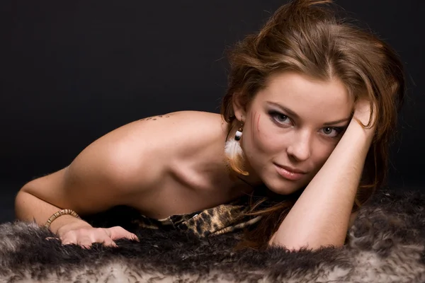 Closeup portrait of young savage woman on fur — Stock Photo, Image