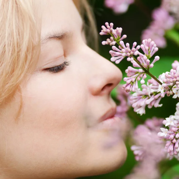 Kobieta z kwiatów bzu na twarz — Zdjęcie stockowe