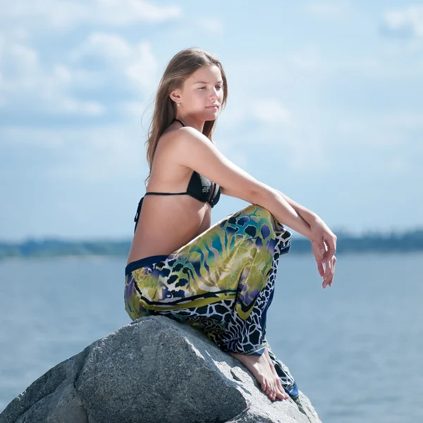 Mulher bonita relaxante na rocha sobre o mar — Fotografia de Stock