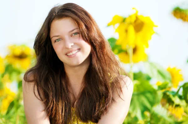 Schöne Frau in einem Sonnenblumenfeld — Stockfoto