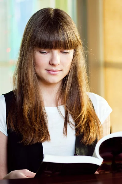 Una giovane donna in un caffè con libro — Foto Stock