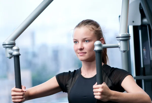 Young woman at the gym exercising — Stock Photo, Image