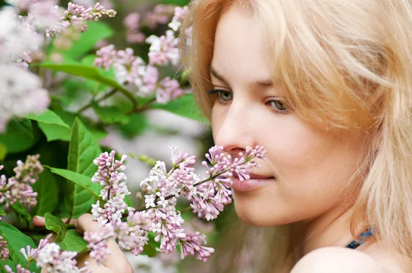 顔にライラックの花を持つ女性 — ストック写真