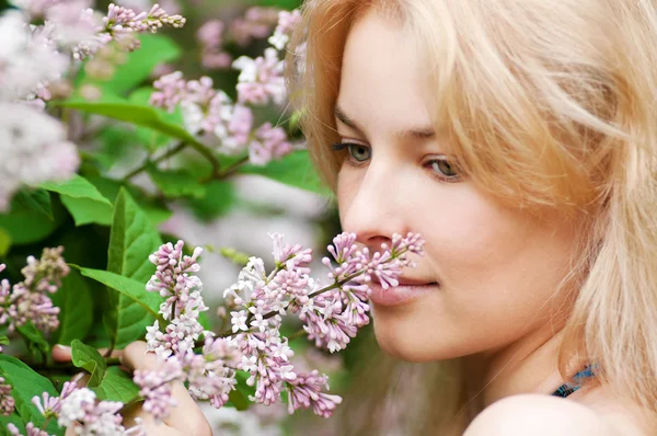 Mulher com flor lilás no rosto — Fotografia de Stock