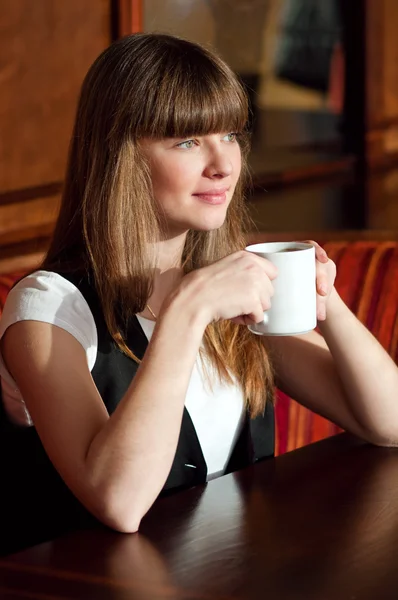 Μια γυναίκα που κάθεται σε ένα καφέ με καφέ — Φωτογραφία Αρχείου