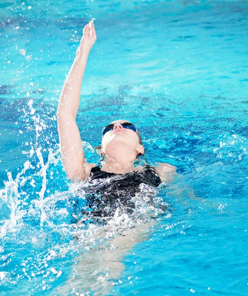 Swimmer in swim meet doing backstroke — Stok fotoğraf