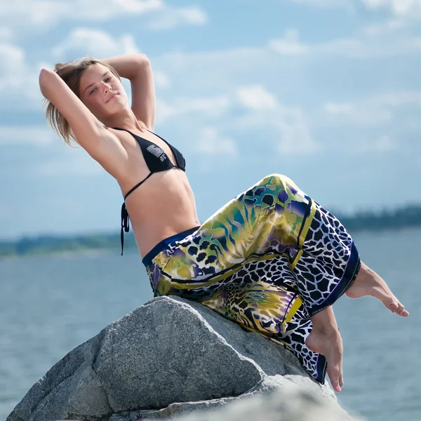 Mulher bonita relaxante na rocha sobre o mar — Fotografia de Stock