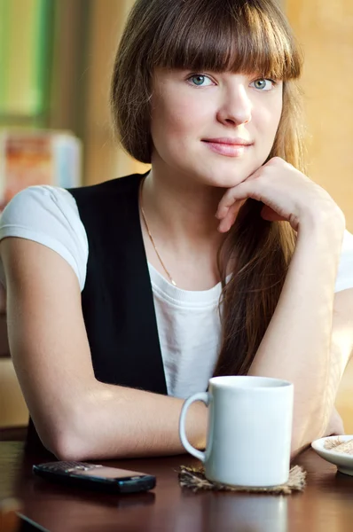 Une femme assise dans un café avec un café — Photo