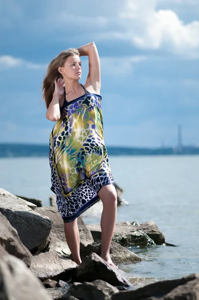 Сумна жінка стоїть на скелі над грозовим морем — стокове фото