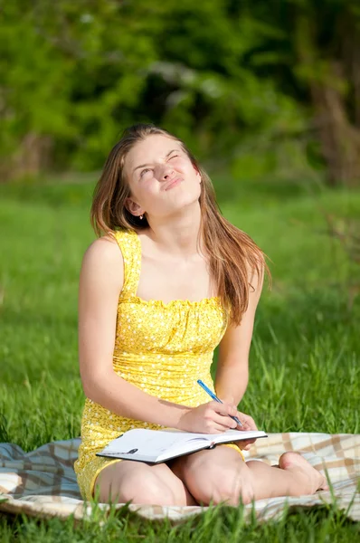 Красивая молодая женщина читает книгу под открытым небом — стоковое фото