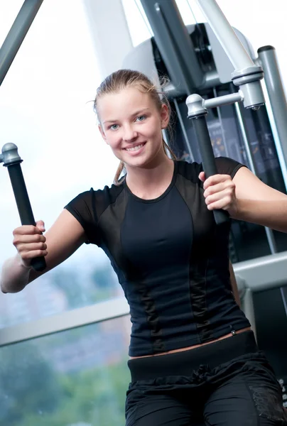 Junge Frau beim Turnen im Fitnessstudio — Stockfoto