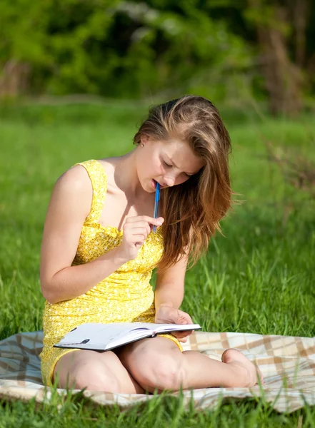 Schöne junge Frau liest Buch im Freien — Stockfoto