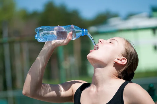 Mujer joven bebiendo agua después del ejercicio —  Fotos de Stock