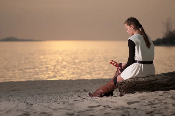 Mujer solitaria sentada en la costa del lago — Foto de Stock