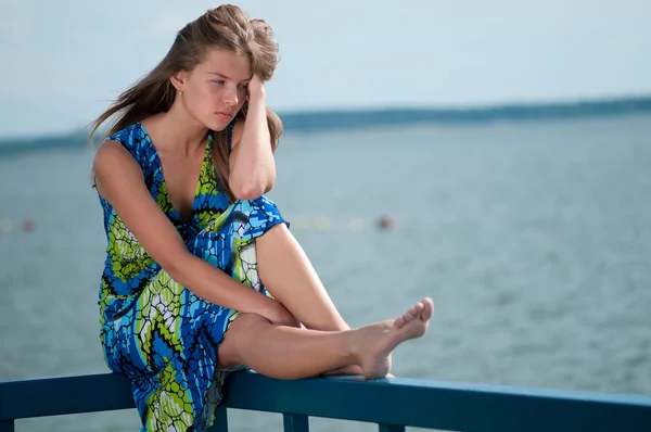 Sad woman sitting over sea at summer day — Stock Photo, Image