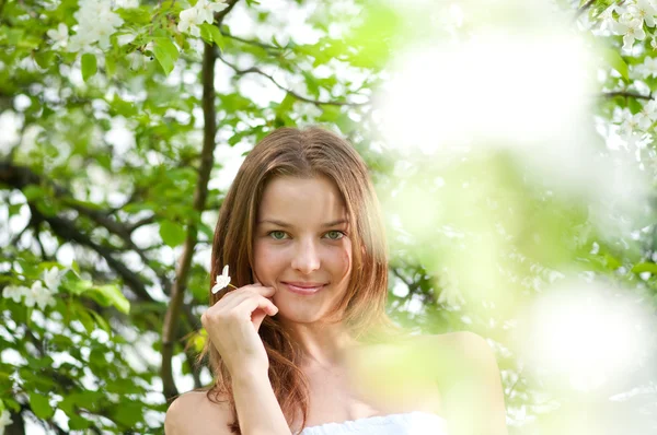 Красива молода жінка розслабляється в саду яблунь — стокове фото
