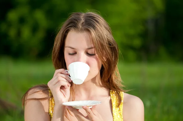 Schöne junge Frau trinken heißen Tee im Freien — Stockfoto