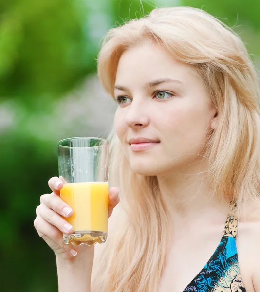 Mosolygó nő iszik narancslé — Stock Fotó