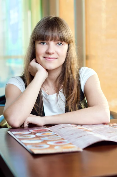 En ung kvinna på ett kafé — Stockfoto