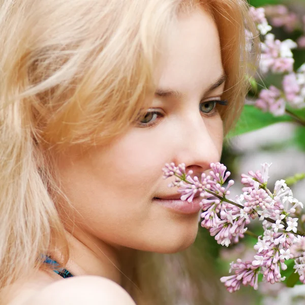 Donna con fiore di lilla sul viso — Foto Stock
