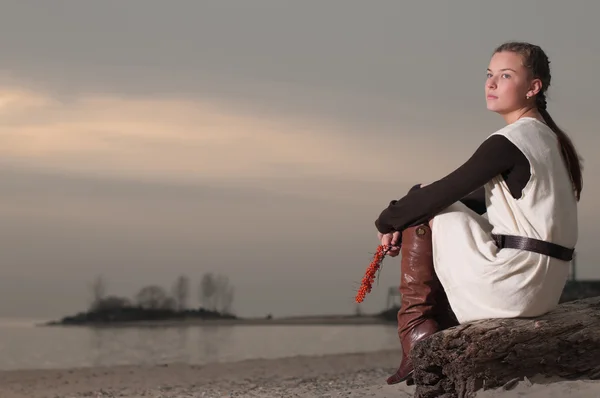 Самотня жінка сидить на березі озера — стокове фото