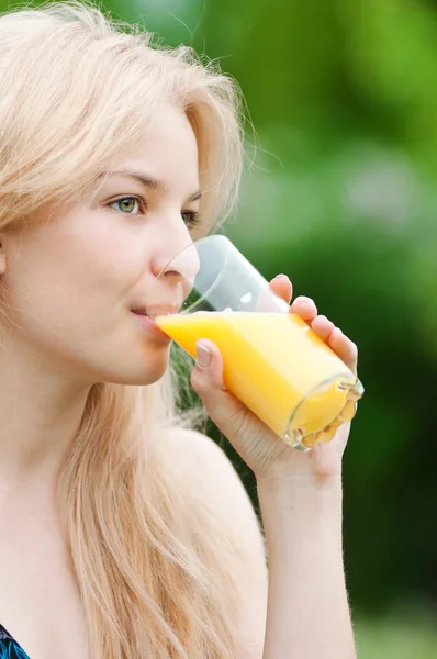 Smiling woman drinking orange juice — Stock Photo, Image