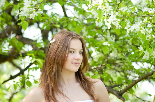 Beautiful young woman relaxing in apple tree garden — Stock Photo, Image